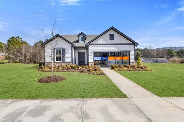 a front view of a house with yard and green space