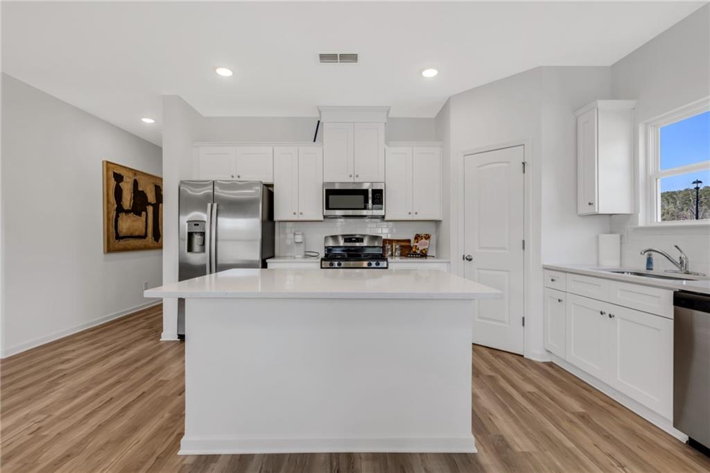 163 Sweet Water Lane Rome, GA 30161 - Photo 12 of 28 a kitchen with kitchen island a white counter top space cabinets and stainless steel appliances
