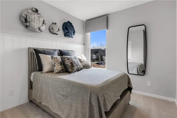 a bedroom with a bed and painting on the wall