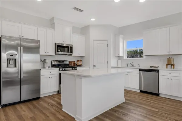 a kitchen with stainless steel appliances a refrigerator sink and stove
