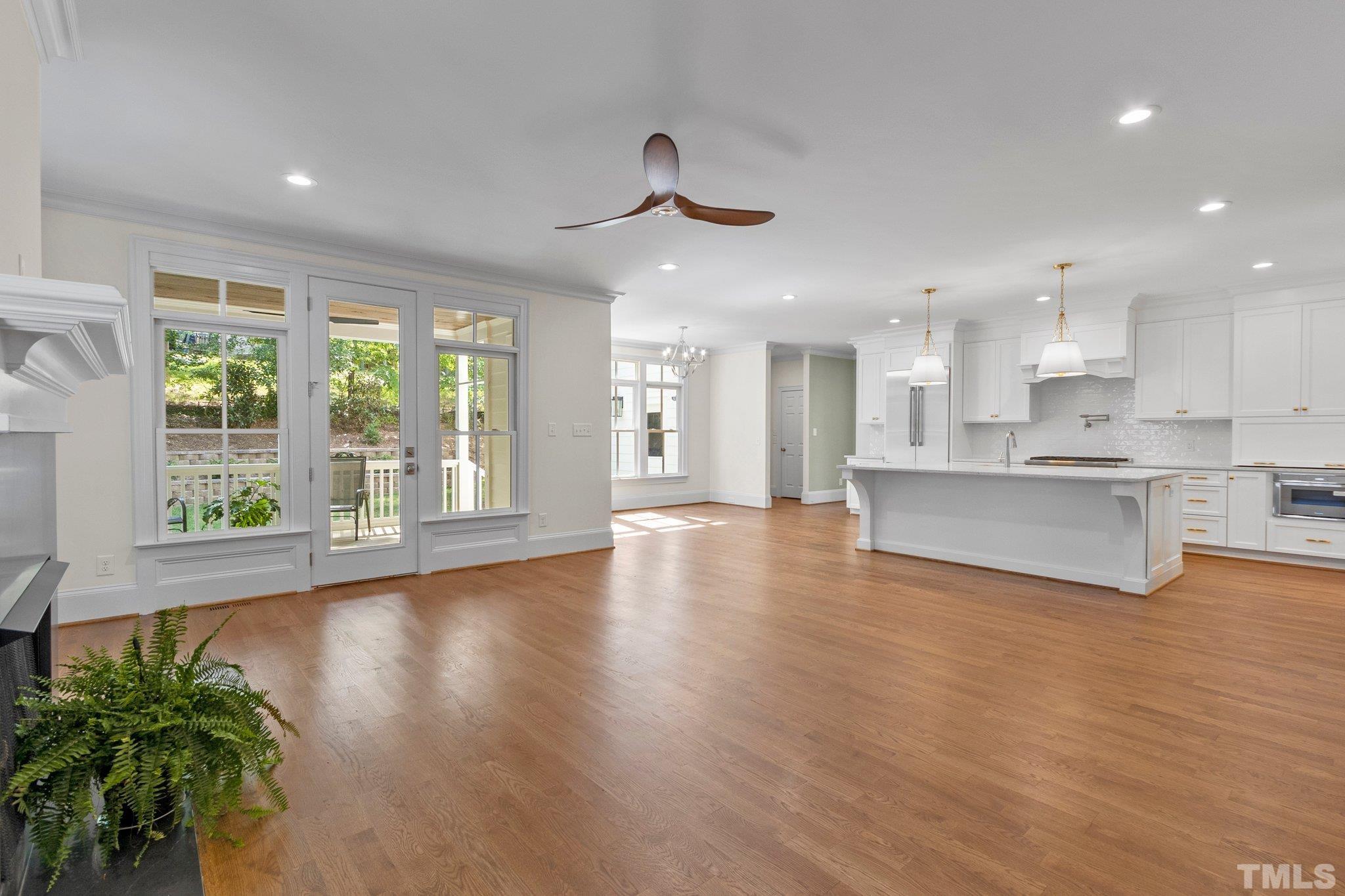 1500 Banbury Road Raleigh, NC 27607 - Photo 12 of 39 a view of an empty room and kitchen with wooden floor and a large window