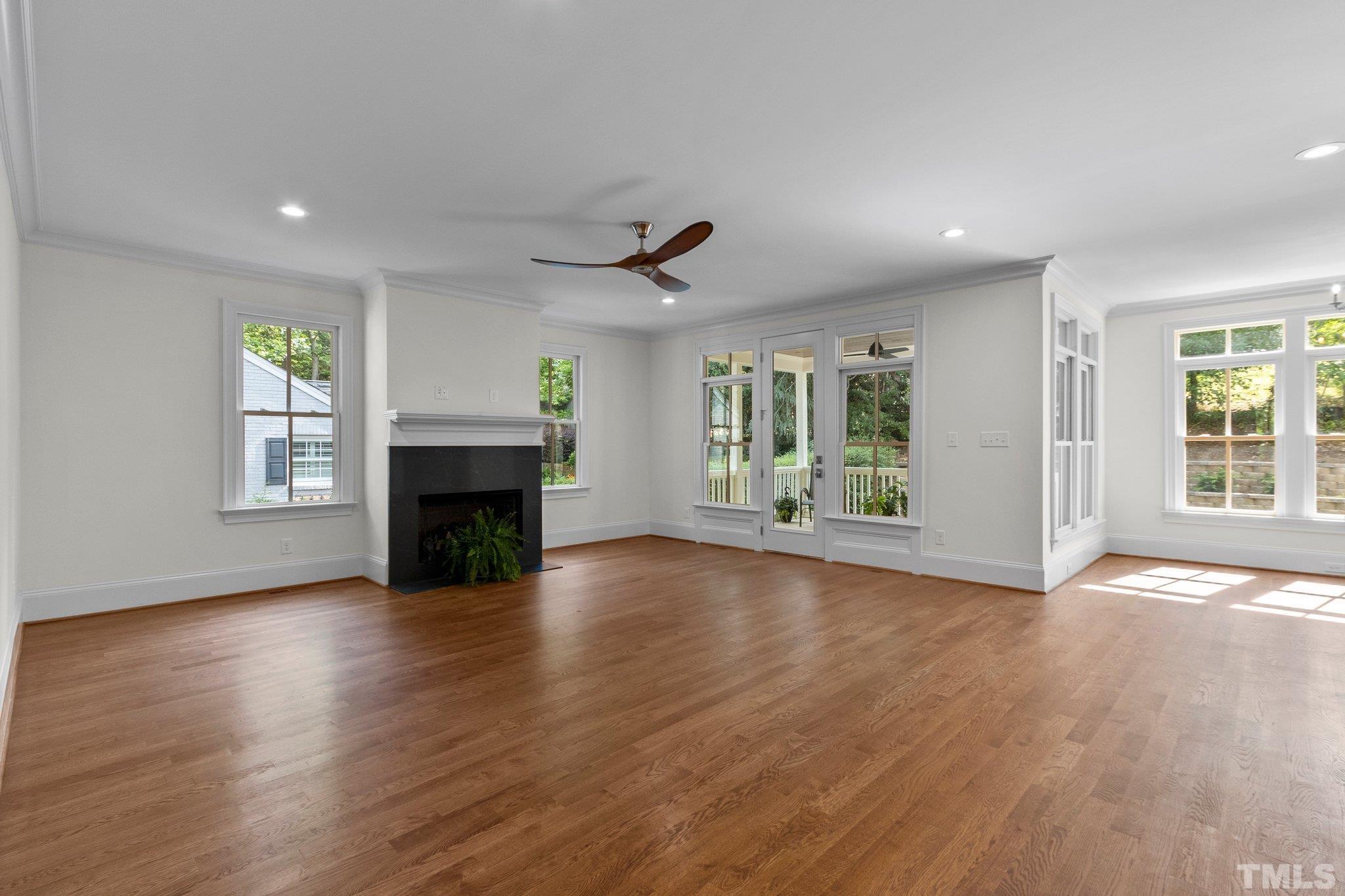 1500 Banbury Road Raleigh, NC 27607 - Photo 16 of 39 an empty room with wooden floor fireplace and windows