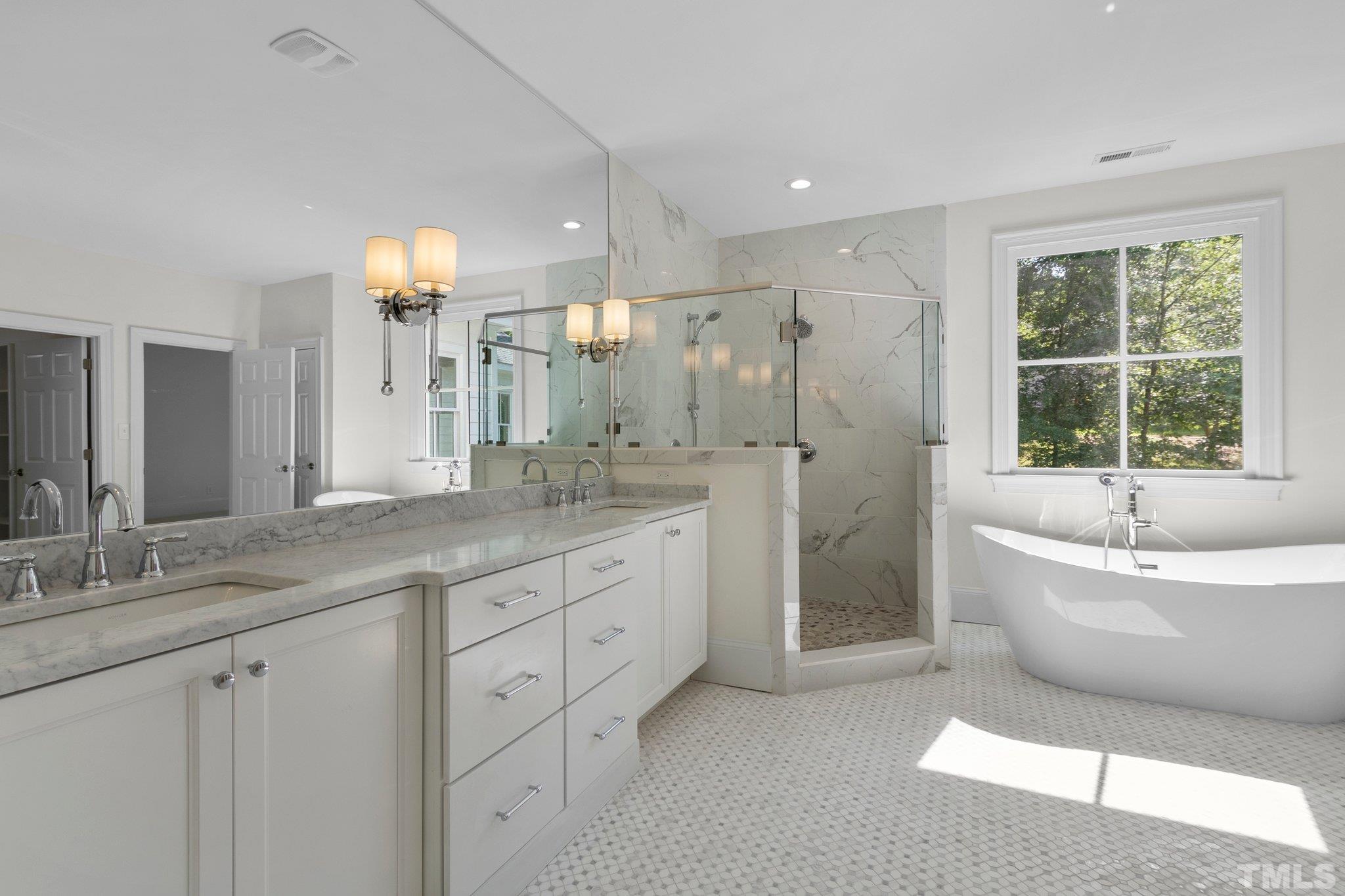 1500 Banbury Road Raleigh, NC 27607 - Photo 20 of 39 a spacious bathroom with a double vanity sink a large mirror and a bathtub