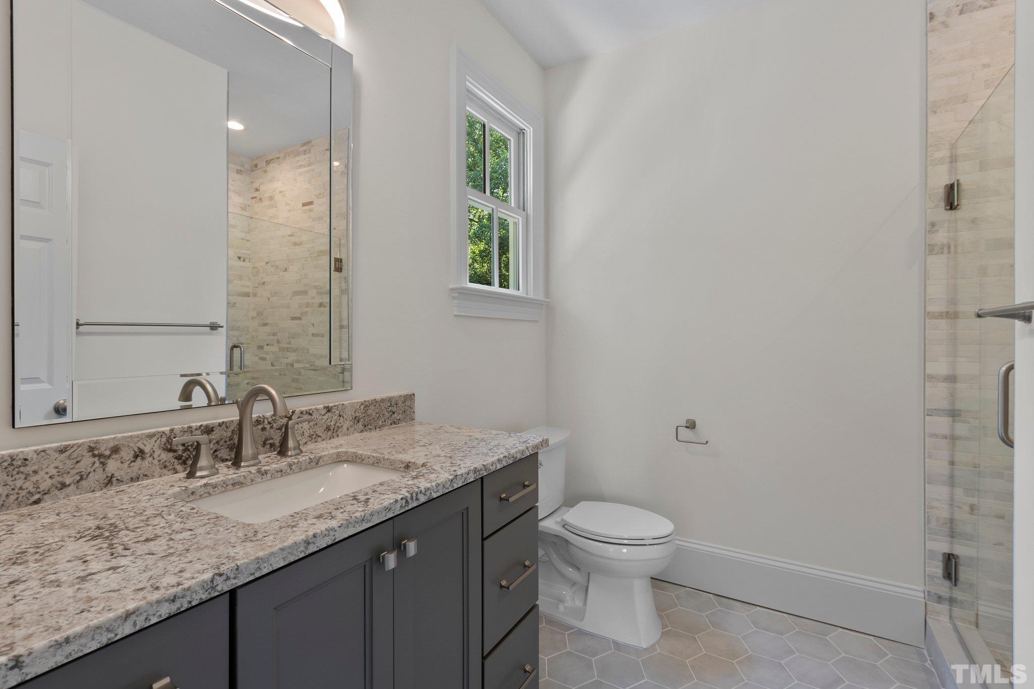 1500 Banbury Road Raleigh, NC 27607 - Photo 28 of 39 a bathroom with a granite countertop sink a toilet and a mirror
