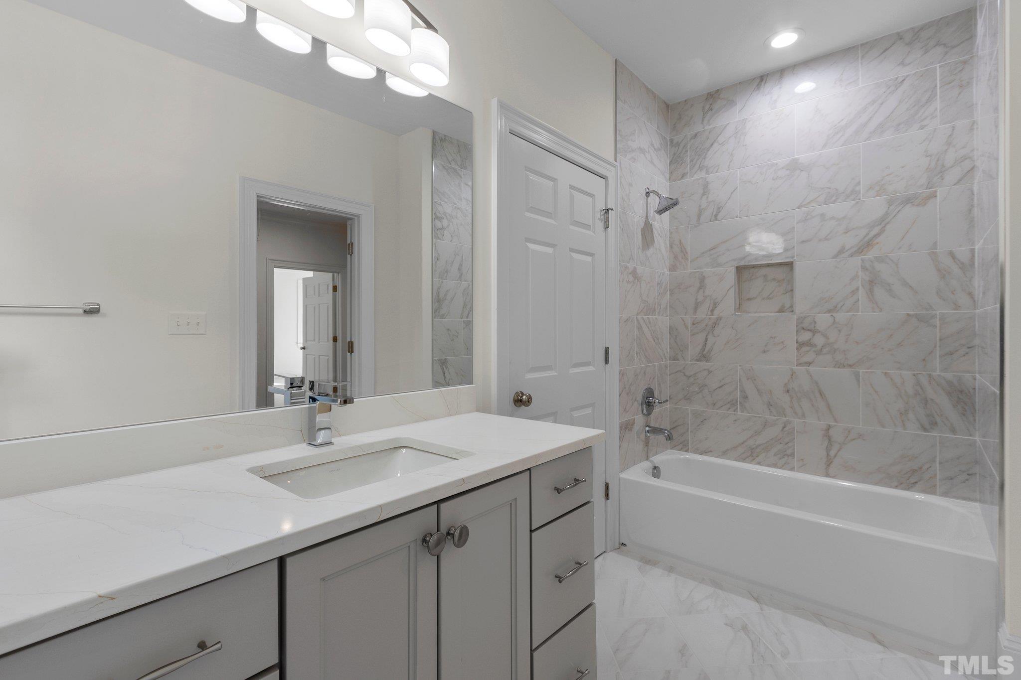 1500 Banbury Road Raleigh, NC 27607 - Photo 31 of 39 a bathroom with a sink double vanity granite tub shower and a mirror