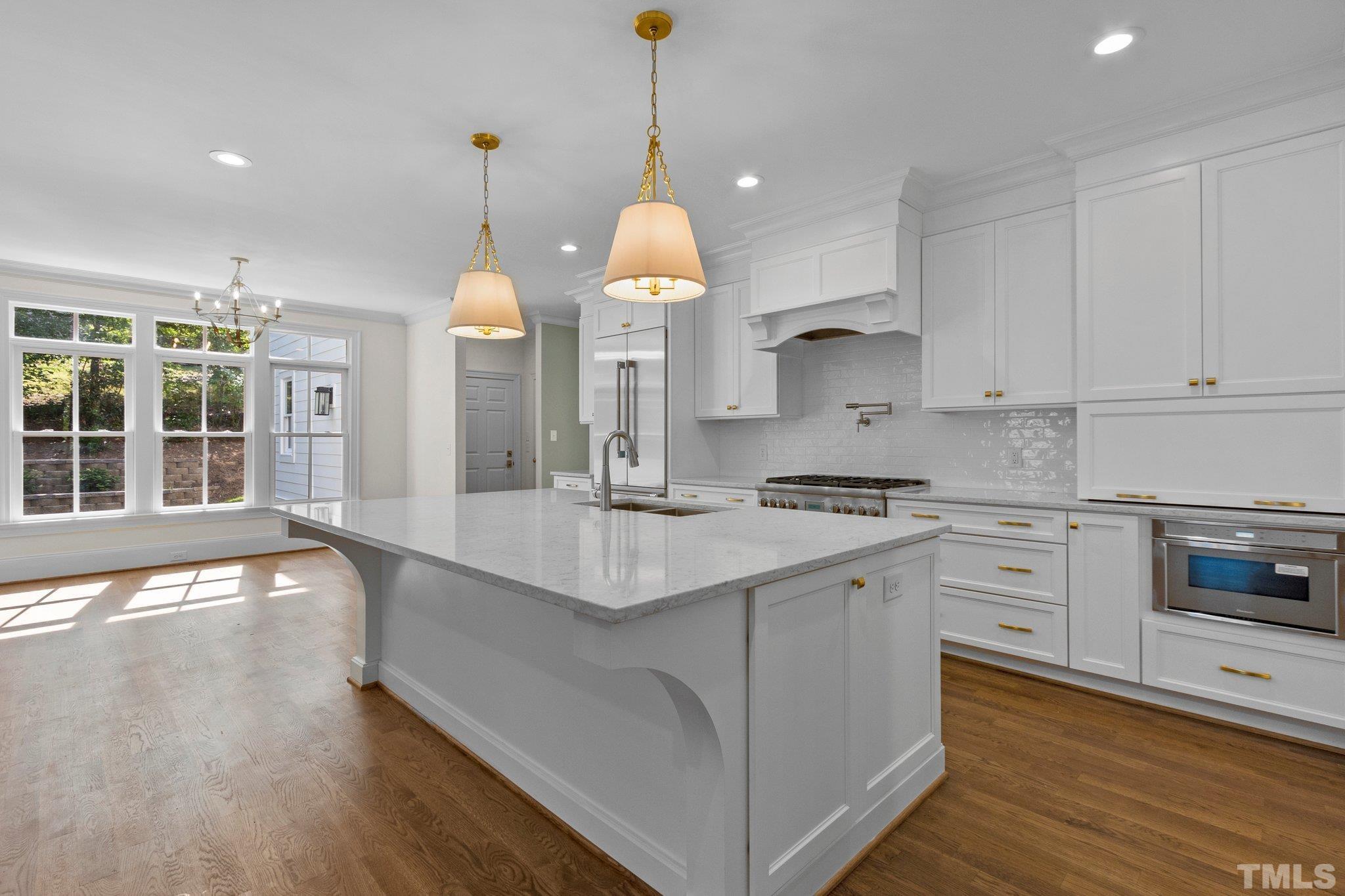 1500 Banbury Road Raleigh, NC 27607 - Photo 9 of 39 a kitchen with stainless steel appliances granite countertop a sink cabinets and wooden floor