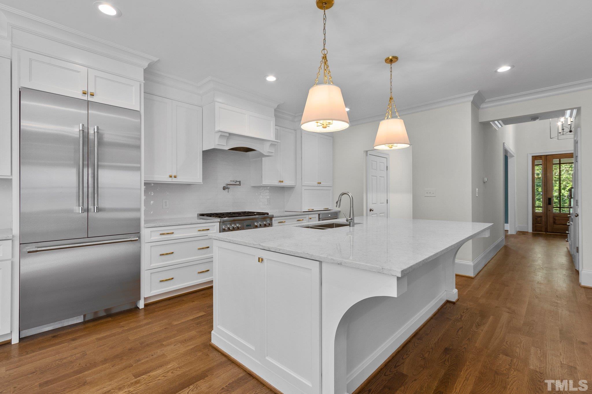 1500 Banbury Road Raleigh, NC 27607 - Photo 10 of 39 a kitchen with kitchen island a sink stainless steel appliances and wooden floor