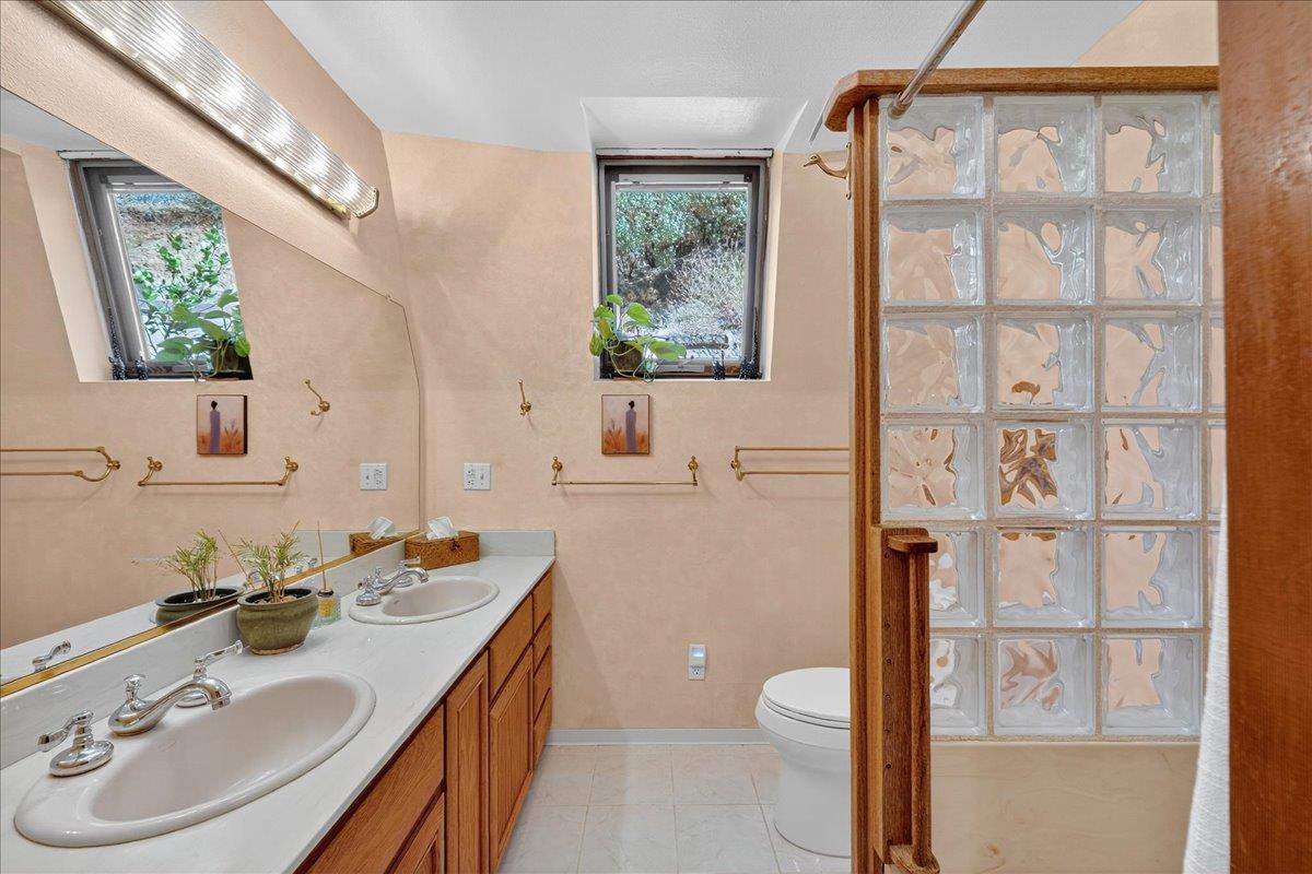 5224 Twin Falls Road Morgan Hill, CA 95037 - Photo 47 of 111 a bathroom with a granite countertop sink toilet a mirror and a shower