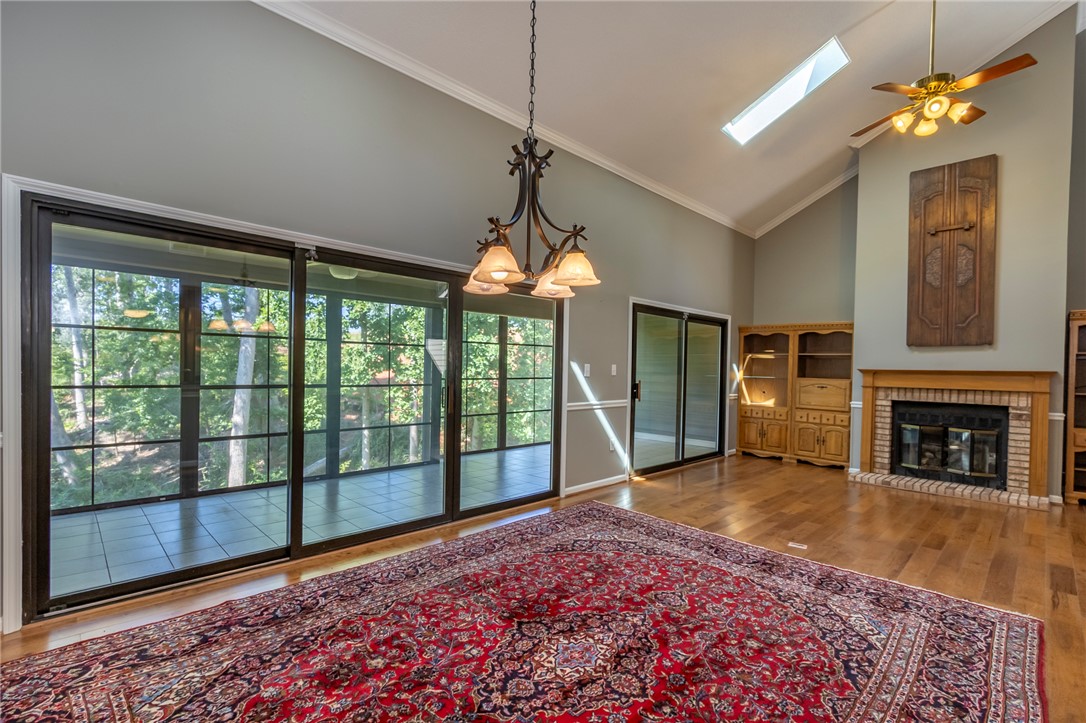 1302 Leeward Road Anderson, SC 29625 - Photo 5 of 50 A spacious living area with hardwood floors, a cozy fireplace, and large glass doors opening to the outdoors.