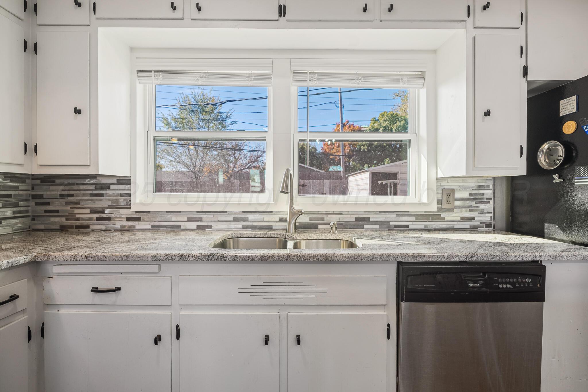 2220 Southeast 19th Avenue Amarillo, TX 79103 - Photo 11 of 25 a kitchen with stainless steel appliances granite countertop white cabinets and a window