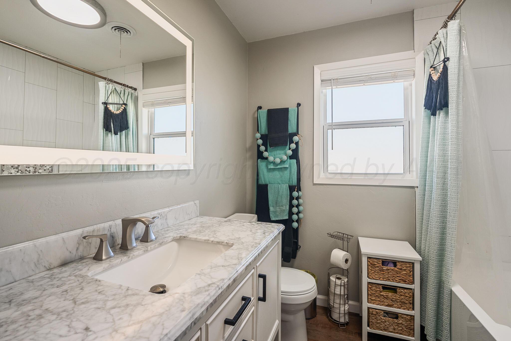 2220 Southeast 19th Avenue Amarillo, TX 79103 - Photo 16 of 25 a bathroom with a sink toilet and a mirror