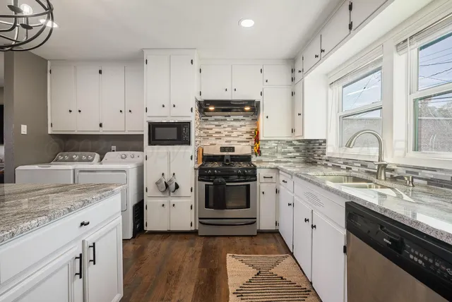 a kitchen with granite countertop white cabinets and white appliances