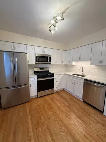 a kitchen with a sink stainless steel appliances and white cabinets