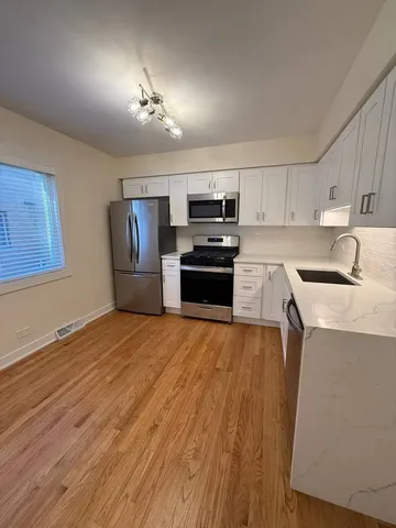 a kitchen with granite countertop a refrigerator stove and sink