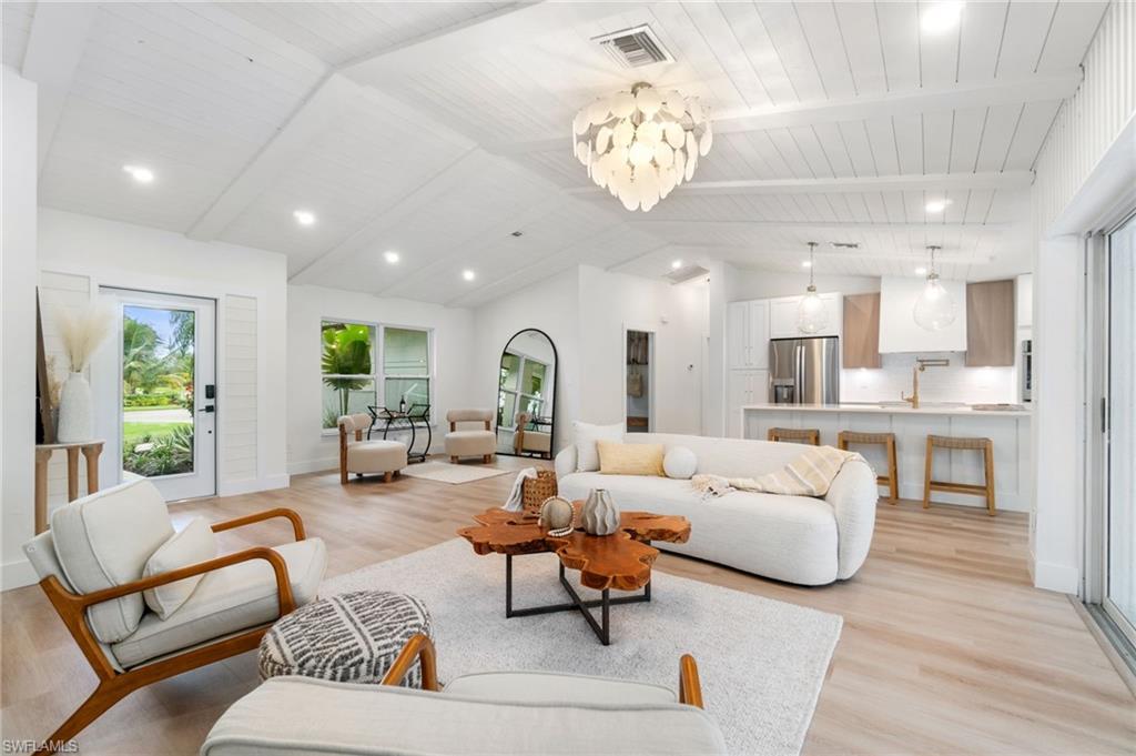 548 Ibis Way Naples, FL 34110 - Photo 11 of 45 a living room with furniture or kitchen view and a chandelier