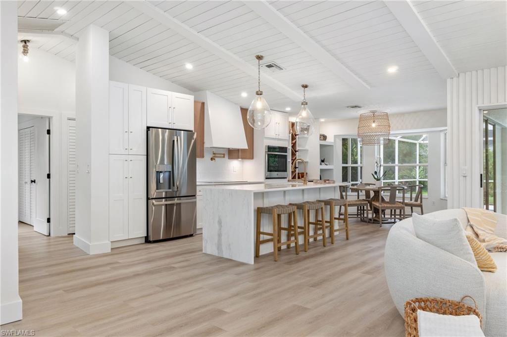 548 Ibis Way Naples, FL 34110 - Photo 12 of 45 a kitchen with stainless steel appliances kitchen island granite countertop a refrigerator and a stove top oven