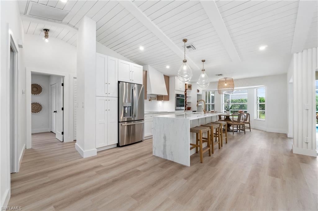 548 Ibis Way Naples, FL 34110 - Photo 13 of 45 a kitchen with refrigerator and cabinets