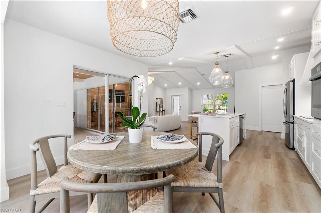 548 Ibis Way Naples, FL 34110 - Photo 18 of 45 a view of a dining room with furniture and wooden floor