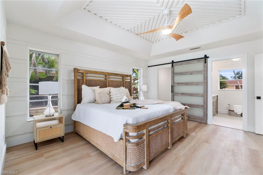 548 Ibis Way Naples, FL 34110 - Photo 20 of 45 a bed sitting in a spacious bedroom next to a window