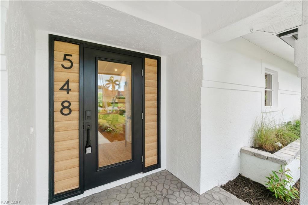 548 Ibis Way Naples, FL 34110 - Photo 34 of 45 a view of a hallway with wooden floor and a dining room