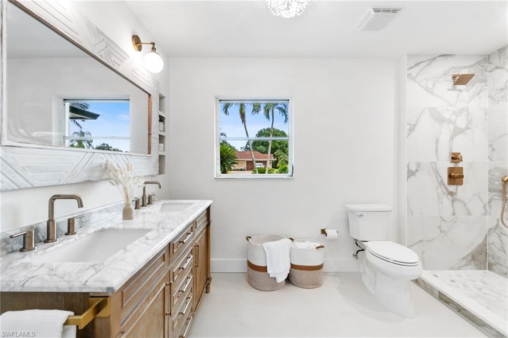 548 Ibis Way Naples, FL 34110 - Photo 6 of 45 a bathroom with a granite countertop sink mirror and toilet