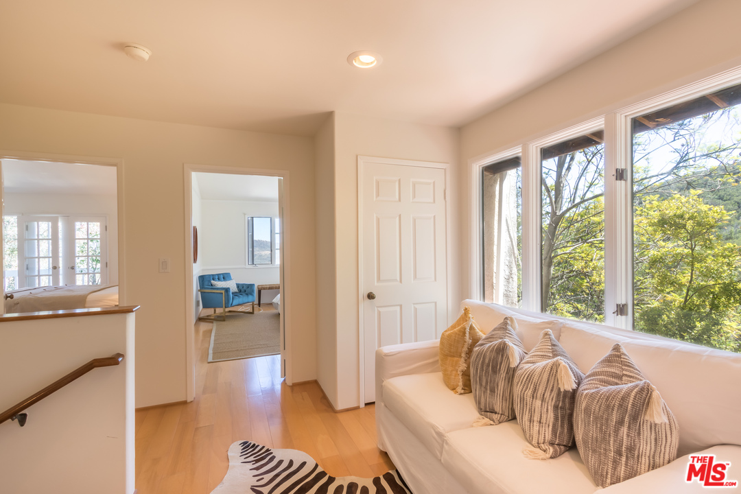 2382 Live Oak Meadows Road Malibu, CA 90265 - Photo 12 of 27 a bedroom with furniture and a wooden floor