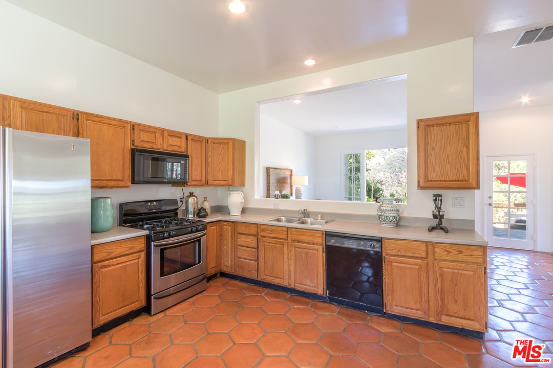 2382 Live Oak Meadows Road Malibu, CA 90265 - Photo 16 of 27 a kitchen with stainless steel appliances granite countertop a sink stove refrigerator and cabinets