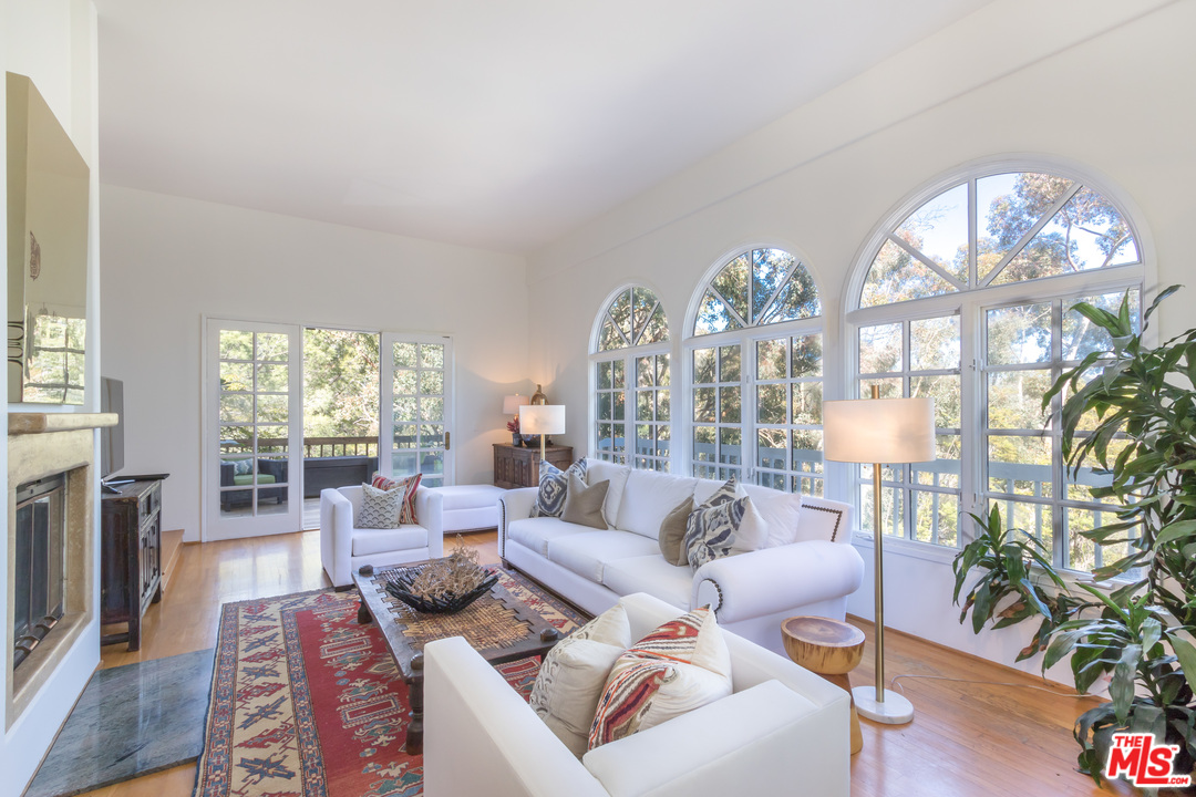 2382 Live Oak Meadows Road Malibu, CA 90265 - Photo 5 of 27 a living room with furniture a chandelier and a large window