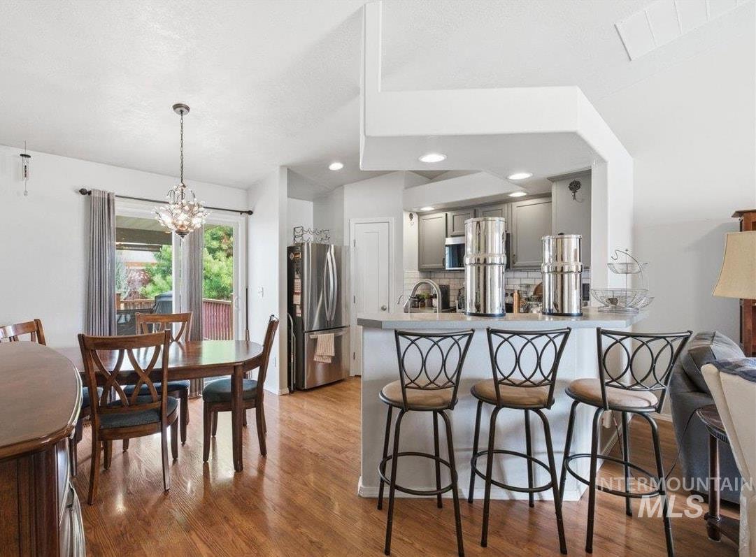 1896 West Ridge Pointe Avenue Nampa, ID 83651 - Photo 12 of 49 Kitchen with a breakfast bar area, a peninsula, stainless steel appliances, gray cabinetry, and light countertops