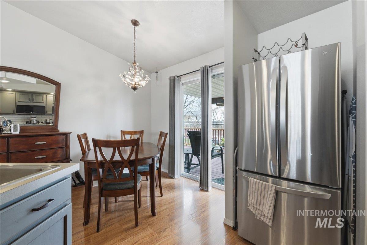 1896 West Ridge Pointe Avenue Nampa, ID 83651 - Photo 13 of 49 Dining space with vaulted ceiling, light wood finished floors, and suspended lighting