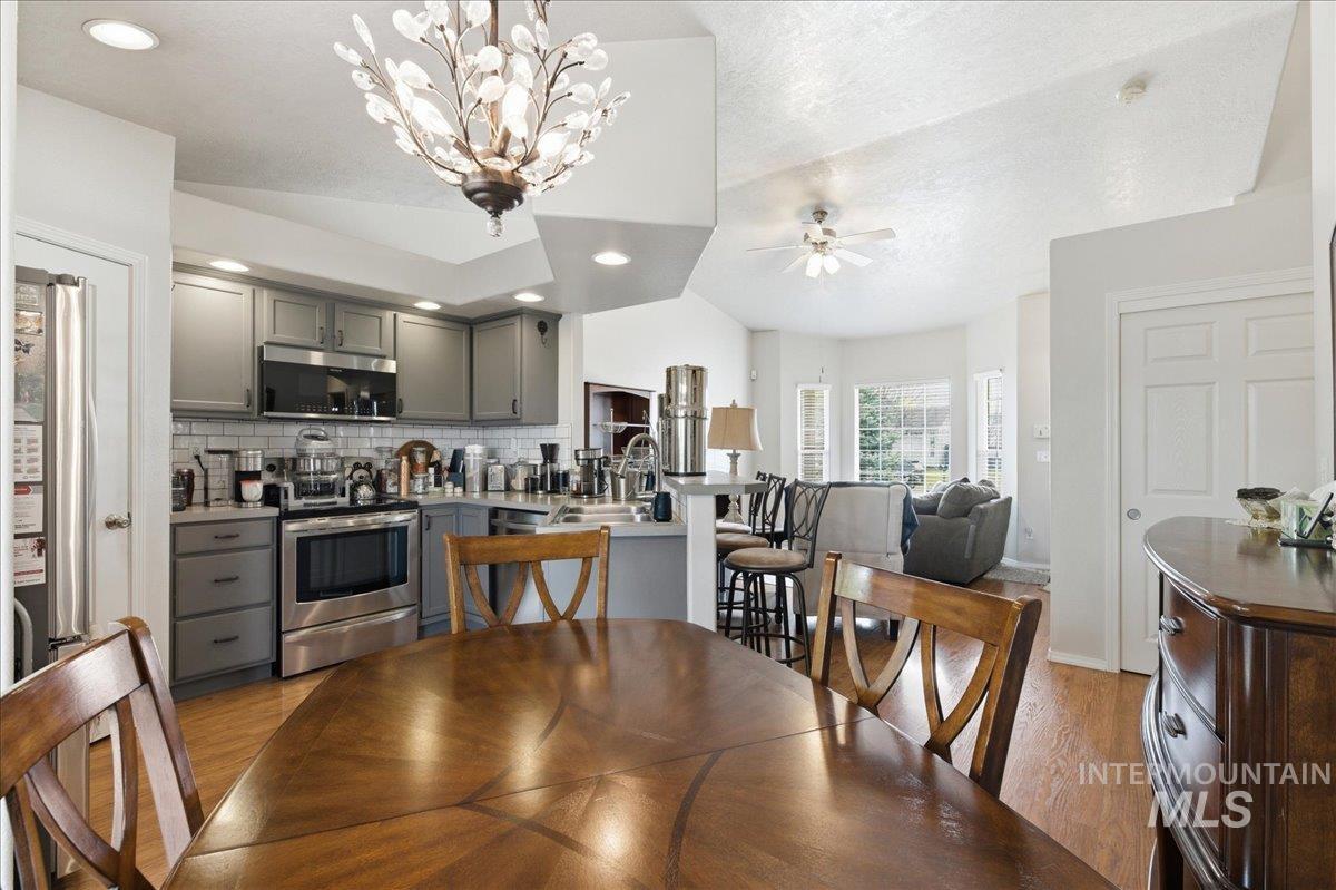 1896 West Ridge Pointe Avenue Nampa, ID 83651 - Photo 16 of 49 Dining room with light wood-style flooring, ceiling fan, and a chandelier