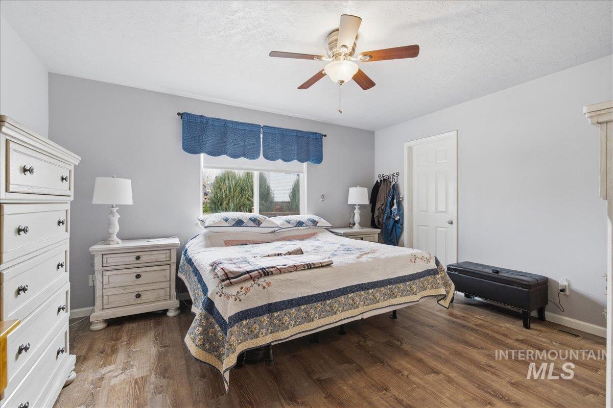 1896 West Ridge Pointe Avenue Nampa, ID 83651 - Photo 20 of 49 Bedroom featuring dark wood-style floors, a ceiling fan, and a textured ceiling