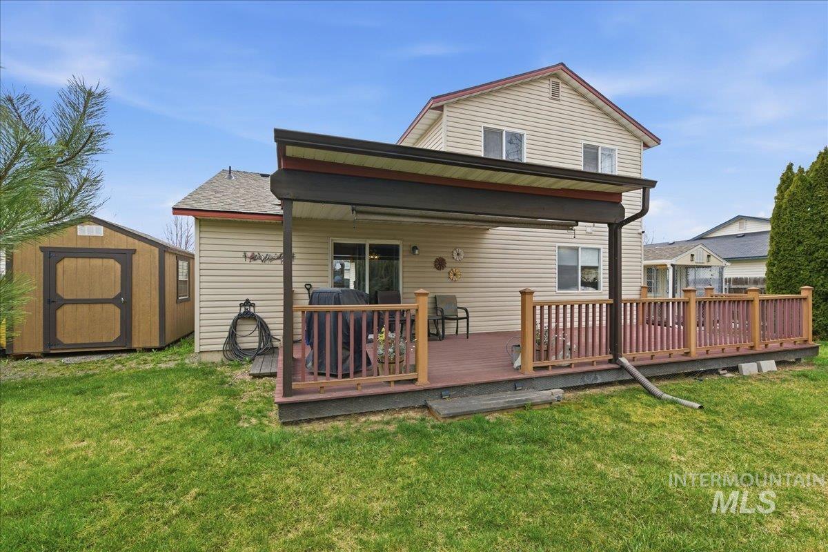 1896 West Ridge Pointe Avenue Nampa, ID 83651 - Photo 36 of 49 Back of property with a storage shed, a yard, and a wooden deck