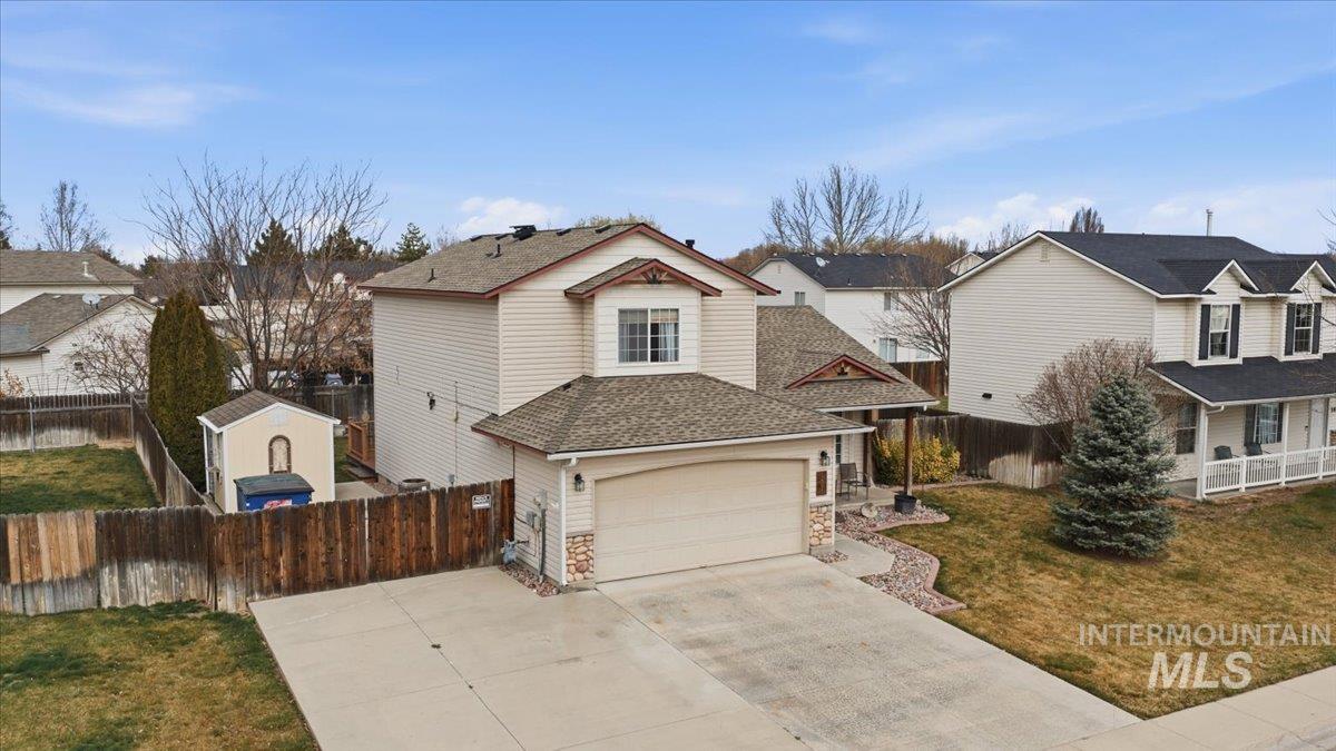 1896 West Ridge Pointe Avenue Nampa, ID 83651 - Photo 43 of 49 Traditional-style house featuring roof with shingles, driveway, a residential view, and stone siding