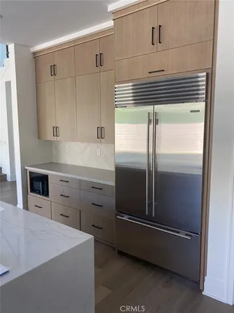 a kitchen with a refrigerator and white cabinets