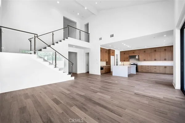 a view of entryway and kitchen with wooden floor