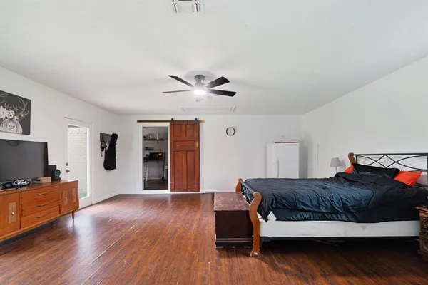 a bedroom with a bed and wooden floor
