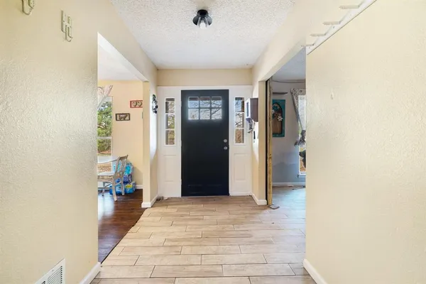 a view of a hallway with wooden floor and furniture