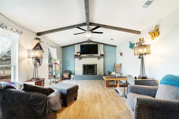a living room with furniture a fireplace and a flat screen tv