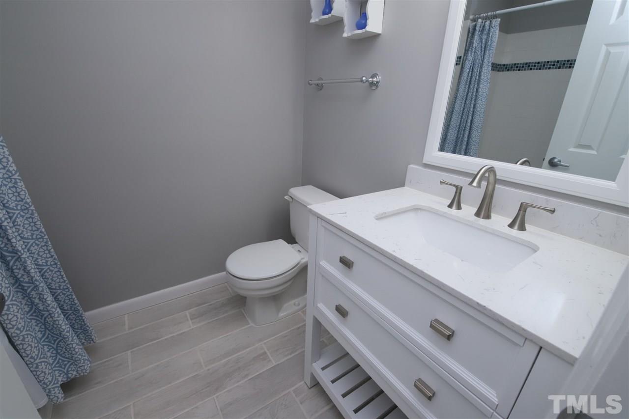 6708 Chauncey Drive Raleigh, NC 27615 - Photo 18 of 25 a bathroom with a sink a toilet and a mirror