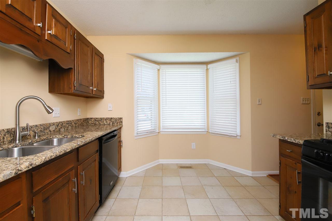 6708 Chauncey Drive Raleigh, NC 27615 - Photo 4 of 25 a kitchen with a sink a stove and cabinets