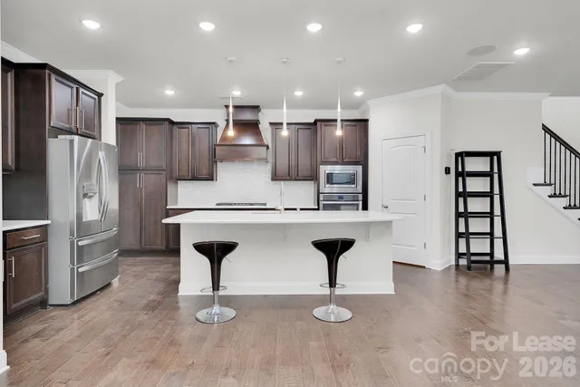 a kitchen with stainless steel appliances a sink a table and chairs
