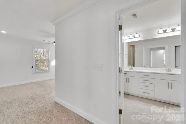 en empty room with windows and ceiling fan