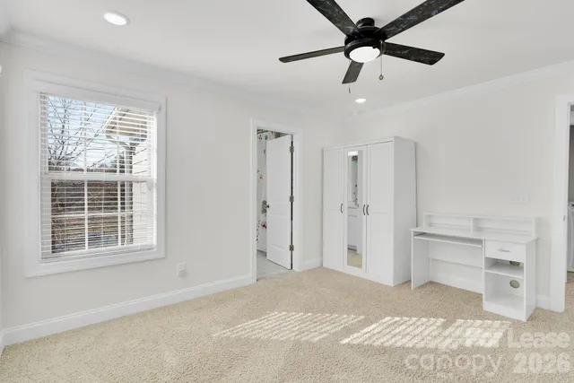 a bathroom with double vanity sink a toilet a window and shower