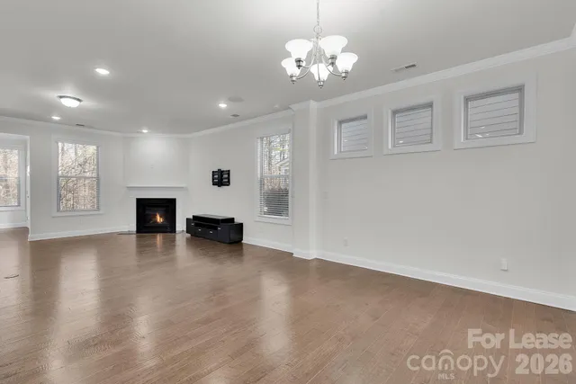 a view of empty room with wooden floor and a fireplace