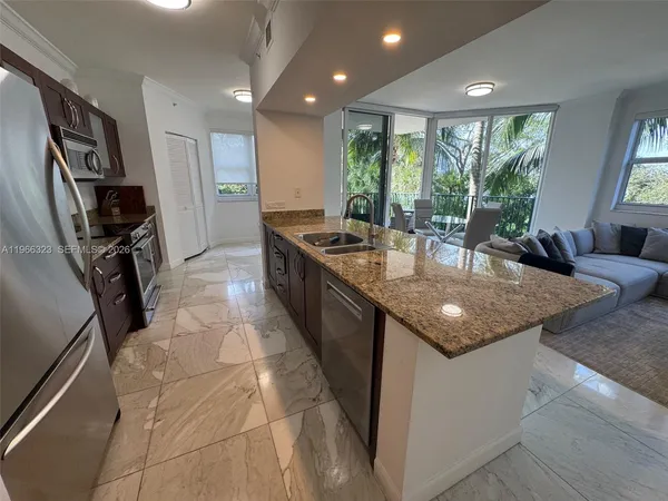 a kitchen with kitchen island granite countertop a sink stove and refrigerator