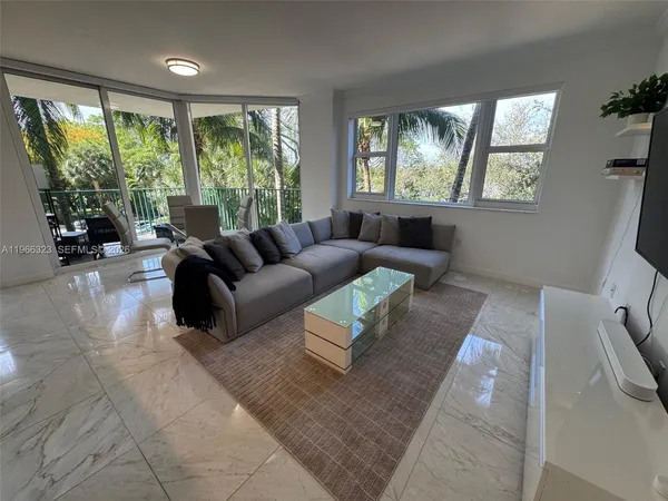 a living room with furniture and large windows