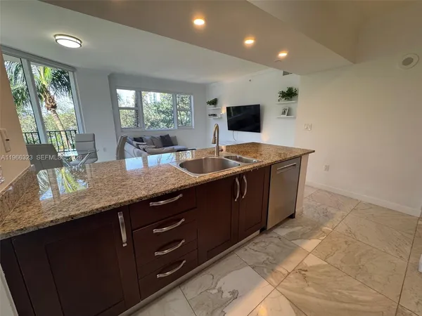 a kitchen with granite countertop a sink and a wooden floor