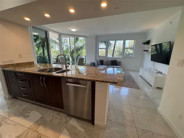 a kitchen with kitchen island granite countertop a sink table and chairs