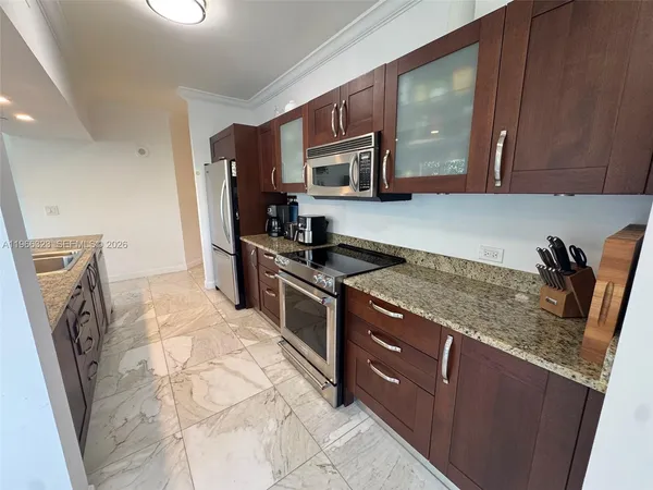 a kitchen with stainless steel appliances granite countertop a stove a sink and a microwave